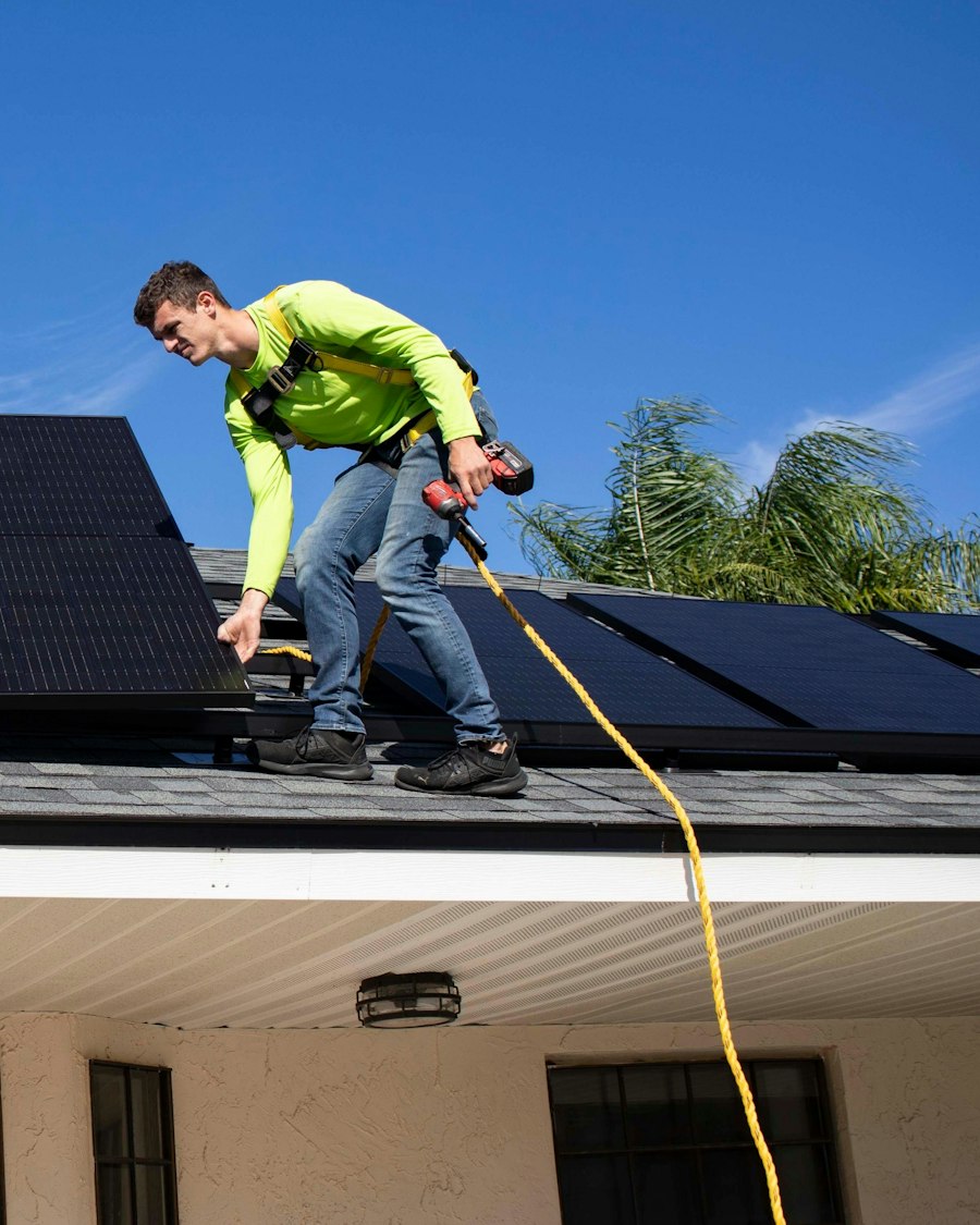 Dois técnicos a montar painéis solares num telhado